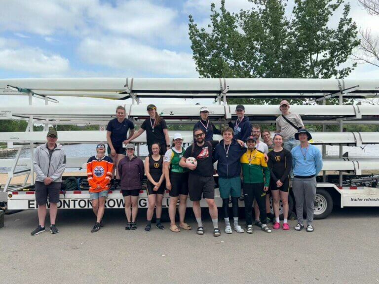 Edmonton Rowing Club athletes pose in front of their boat trailer after competing at the 2024 Western Canada Sprints Regatta in Regina, wearing medals and team gear.